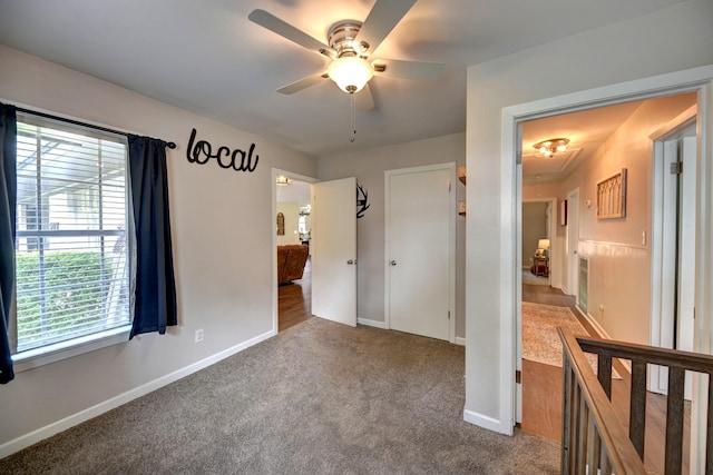 507 Sandra Dr, Brenham, TX 77833 - unfurnished bedroom featuring dark carpet, baseboards, ceiling fan, and attic access