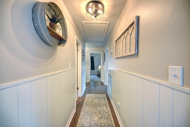 507 Sandra Dr, Brenham, TX 77833 - hall with attic access, dark wood finished floors, wainscoting, and a decorative wall