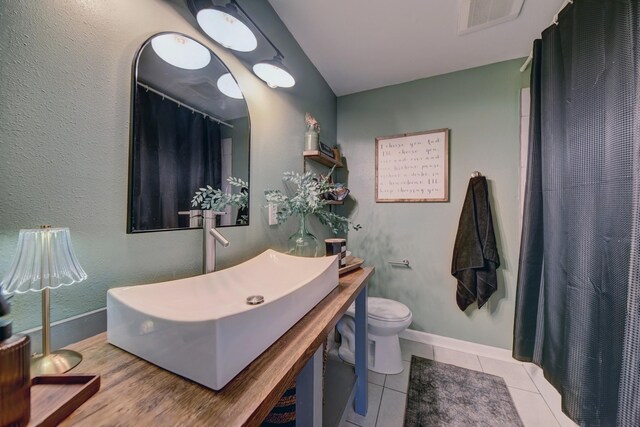 507 Sandra Dr, Brenham, TX 77833 - bathroom featuring toilet, a shower with shower curtain, vanity, tile patterned flooring, and baseboards