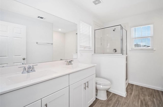10721 Bancroft Park Ln, Houston, TX 77075 - full bathroom featuring toilet, wood finished floors, a shower stall, double vanity, and baseboards