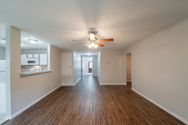 19914 Big Timber Dr, Humble, TX 77346 - unfurnished living room with dark wood-type flooring, a ceiling fan, and baseboards