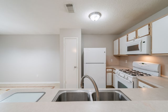 19914 Big Timber Dr, Humble, TX 77346 - kitchen featuring white appliances, light countertops, and white cabinetry