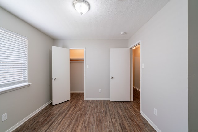 19914 Big Timber Dr, Humble, TX 77346 - unfurnished bedroom featuring wood finished floors, a closet, a spacious closet, and a textured ceiling