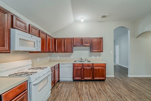 2511 Muscory Dr, Humble, TX 77396 - kitchen with white appliances, a sink, arched walkways, wood finished floors, and vaulted ceiling