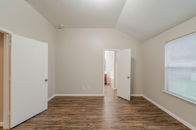 2511 Muscory Dr, Humble, TX 77396 - unfurnished bedroom with wood finished floors, vaulted ceiling, and baseboards