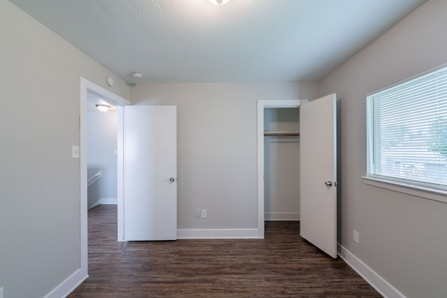 447 Vane Way, Crosby, TX 77532 - unfurnished bedroom featuring dark wood-style flooring, baseboards, and a closet
