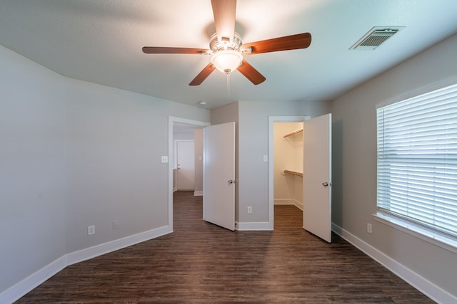 447 Vane Way, Crosby, TX 77532 - unfurnished bedroom with dark wood-type flooring, a spacious closet, baseboards, and a ceiling fan