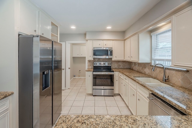 5206 Graystone Ln, Houston, TX 77069 - kitchen featuring appliances with stainless steel finishes, a sink, light tile patterned flooring, tasteful backsplash, and recessed lighting