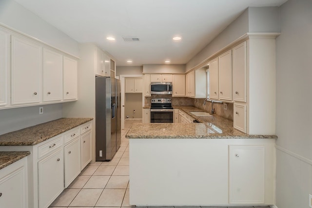5206 Graystone Ln, Houston, TX 77069 - kitchen featuring stainless steel appliances, a sink, light tile patterned floors, light stone counters, and recessed lighting