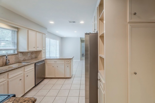 5206 Graystone Ln, Houston, TX 77069 - kitchen featuring stainless steel appliances, a sink, light tile patterned floors, a peninsula, and tasteful backsplash