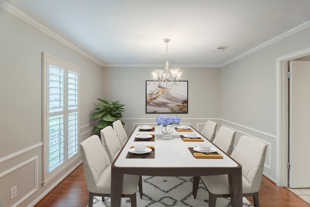 5206 Graystone Ln, Houston, TX 77069 - dining space with crown molding, a chandelier, wood finished floors, and a wainscoted wall