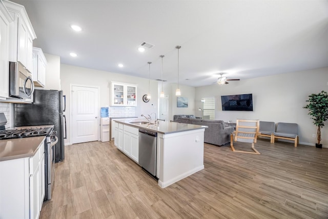 6846 Termino Ln, Rosharon, TX 77583 - kitchen with appliances with stainless steel finishes, a sink, ceiling fan, open floor plan, and an island with sink