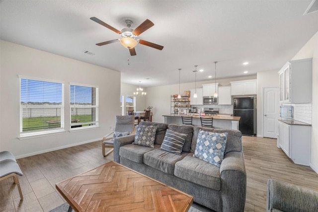 6846 Termino Ln, Rosharon, TX 77583 - living room featuring ceiling fan, a chandelier, baseboards, light wood-type flooring, and recessed lighting