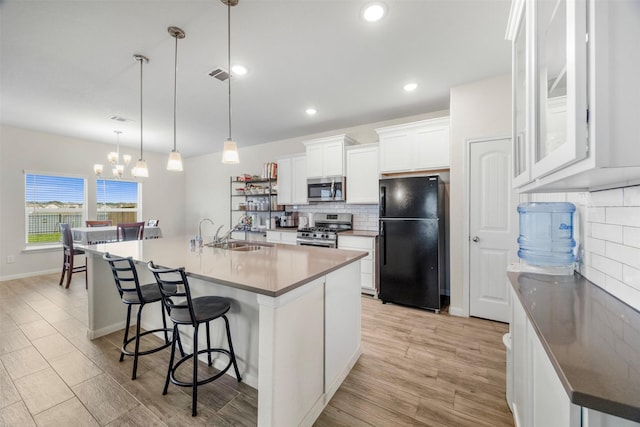 6846 Termino Ln, Rosharon, TX 77583 - kitchen with appliances with stainless steel finishes, a sink, tasteful backsplash, a chandelier, and white cabinets