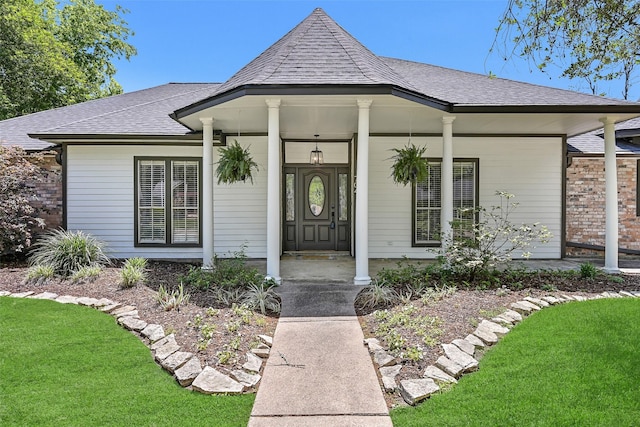 704 Balmoral Ct, Friendswood, TX 77546 - view of exterior entry with a shingled roof, covered porch, and a yard
