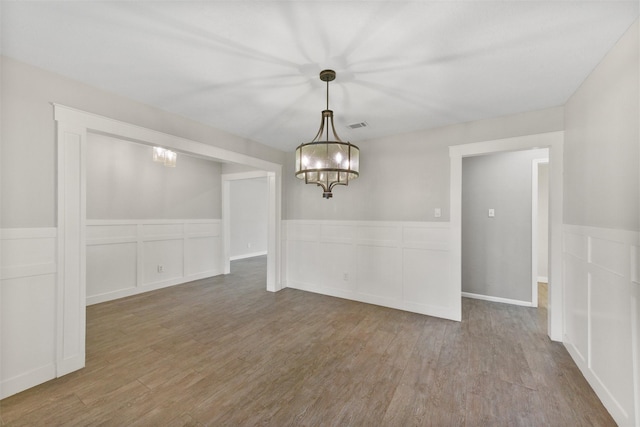 704 Balmoral Ct, Friendswood, TX 77546 - unfurnished dining area featuring wood finished floors, a chandelier, and a wainscoted wall