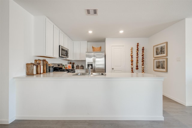277 Douglas Hills Dr, Magnolia, TX 77354 - kitchen featuring stainless steel appliances, a sink, a peninsula, light countertops, and baseboards
