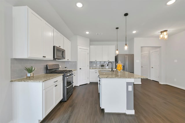 12307 Sabine Point Dr, Humble, TX 77346 - kitchen with appliances with stainless steel finishes, a sink, dark wood-style flooring, white cabinets, and recessed lighting