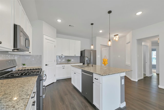 12307 Sabine Point Dr, Humble, TX 77346 - kitchen with stainless steel appliances, a sink, dark wood-style floors, tasteful backsplash, and a center island with sink