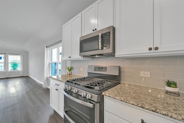 12307 Sabine Point Dr, Humble, TX 77346 - kitchen featuring stainless steel appliances, decorative backsplash, white cabinets, light stone counters, and baseboards