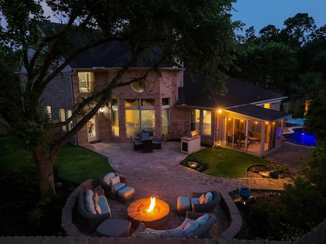 11802 Rue Saint Honore Ct, Tomball, TX 77377 - rear view of house with a patio area, brick siding, an outdoor living space with a fire pit, and a lawn