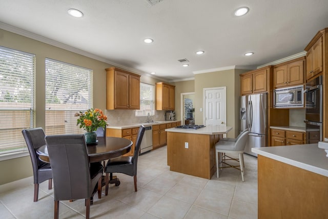 11802 Rue Saint Honore Ct, Tomball, TX 77377 - kitchen with appliances with stainless steel finishes, a sink, a center island, ornamental molding, and a breakfast bar