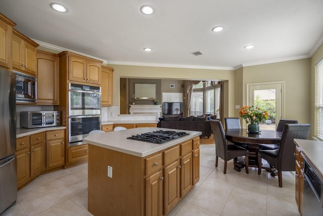 11802 Rue Saint Honore Ct, Tomball, TX 77377 - kitchen with stainless steel appliances, ornamental molding, a kitchen island, light countertops, and light tile patterned flooring