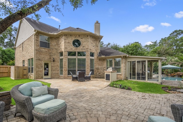 11802 Rue Saint Honore Ct, Tomball, TX 77377 - rear view of house featuring a sunroom, a patio, a chimney, brick siding, and a gate