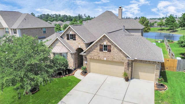22714 Wilbur Ln, Tomball, TX 77375 - view of front of house with driveway, roof with shingles, a chimney, brick siding, and stone siding