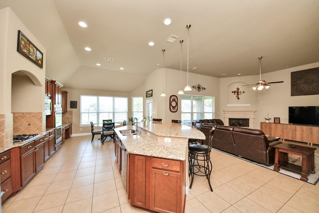 22714 Wilbur Ln, Tomball, TX 77375 - kitchen with a sink, decorative backsplash, a breakfast bar area, a fireplace, and light tile patterned floors