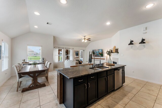 9998 Chimney Swift Ln, Conroe, TX 77385 - kitchen featuring lofted ceiling, a sink, dark stone counters, light tile patterned floors, and dishwasher