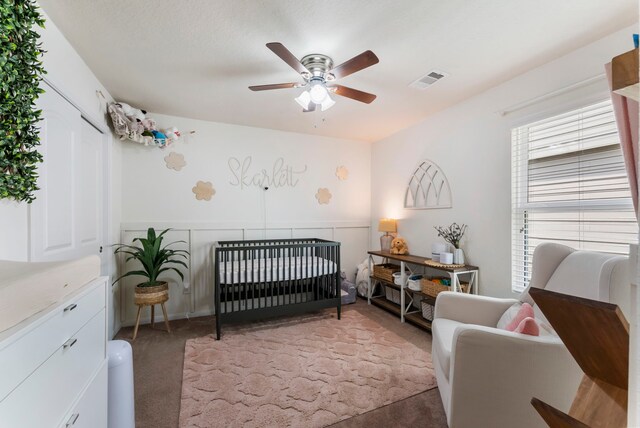 9998 Chimney Swift Ln, Conroe, TX 77385 - bedroom featuring light colored carpet, a crib, and ceiling fan
