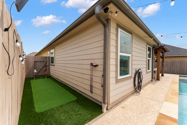 9998 Chimney Swift Ln, Conroe, TX 77385 - view of side of property featuring a putting area, a fenced backyard, a gate, and a patio