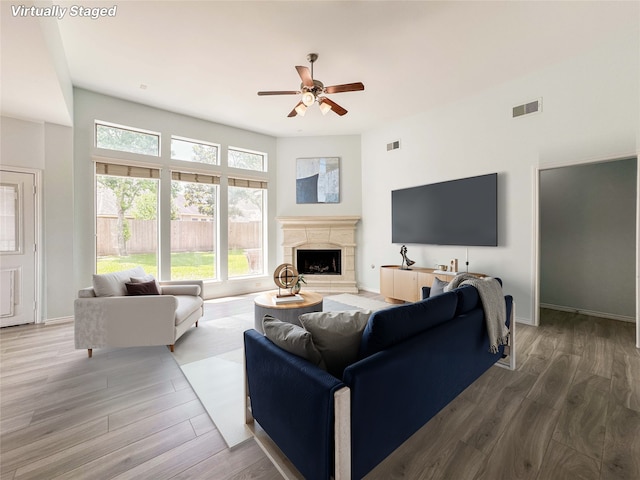 6081 Trent Ct, League City, TX 77573 - living area with a high end fireplace, ceiling fan, wood finished floors, and baseboards