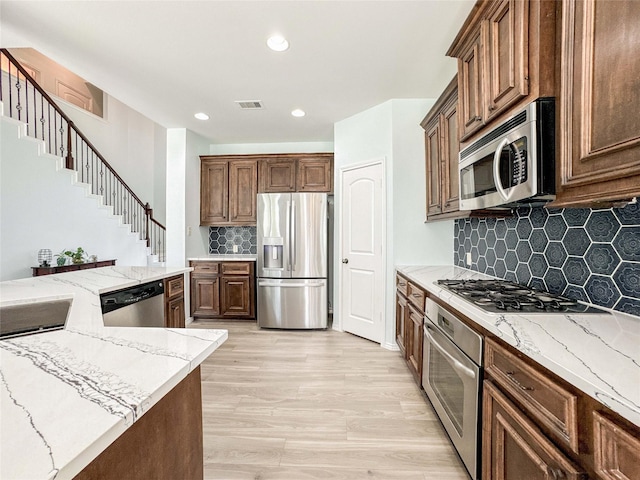 6081 Trent Ct, League City, TX 77573 - kitchen featuring stainless steel appliances, recessed lighting, decorative backsplash, light stone countertops, and light wood-style floors