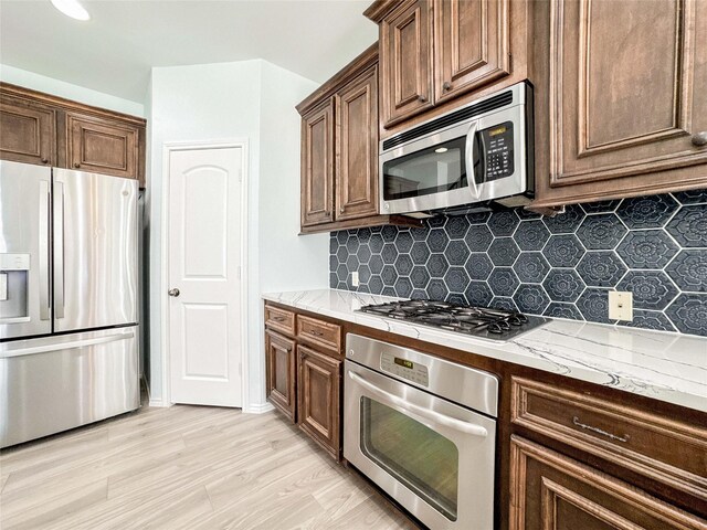 6081 Trent Ct, League City, TX 77573 - kitchen with stainless steel appliances, decorative backsplash, and light stone countertops