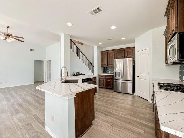 6081 Trent Ct, League City, TX 77573 - kitchen with appliances with stainless steel finishes, a sink, a ceiling fan, light wood finished floors, and recessed lighting