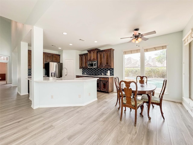 6081 Trent Ct, League City, TX 77573 - kitchen with appliances with stainless steel finishes, light countertops, decorative backsplash, light wood-style flooring, and recessed lighting