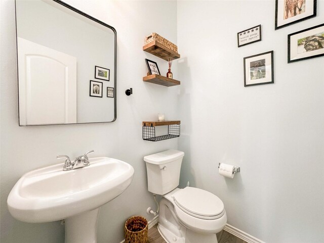 6081 Trent Ct, League City, TX 77573 - bathroom with baseboards, toilet, a sink, and wood finished floors