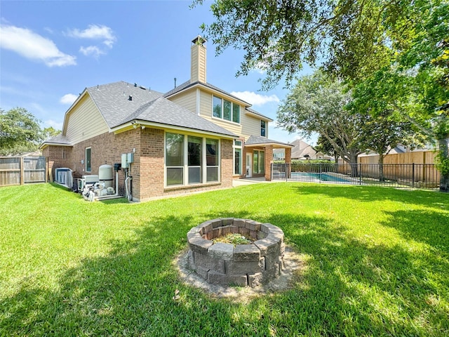 6081 Trent Ct, League City, TX 77573 - back of property featuring brick siding, an outdoor fire pit, a shingled roof, a chimney, and a patio area
