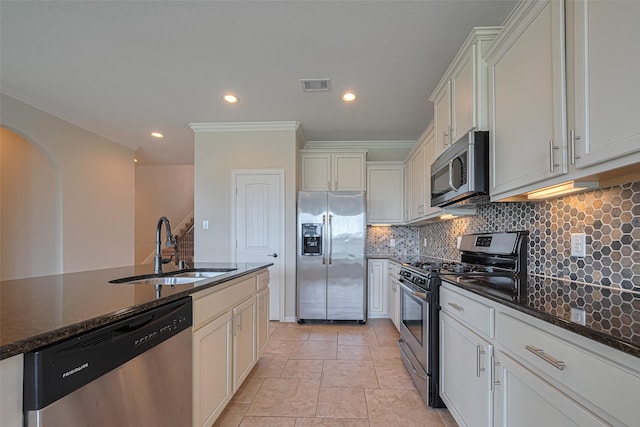 20619 Cactus Lake Ln, Richmond, TX 77407 - kitchen featuring stainless steel appliances, a sink, backsplash, dark stone countertops, and arched walkways