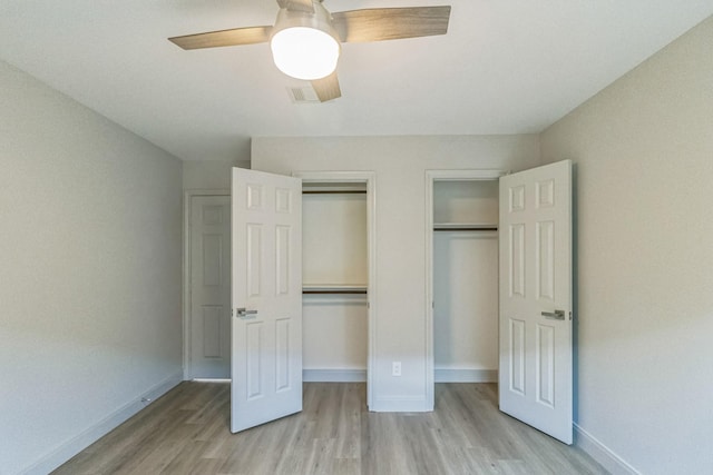 14147 Hillvale Dr, Houston, TX 77077 - unfurnished bedroom with light wood finished floors, baseboards, two closets, and ceiling fan