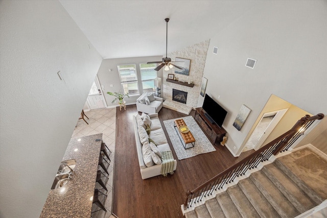 9982 Manor Spring Ln, Brookshire, TX 77423 - living area with a ceiling fan, a stone fireplace, wood finished floors, baseboards, and high vaulted ceiling