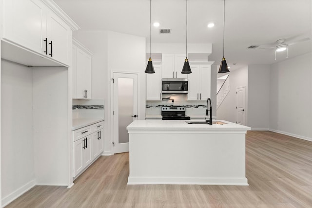 1009 Spokane River Rd, Conroe, TX 77316 - kitchen with appliances with stainless steel finishes, a sink, tasteful backsplash, light wood finished floors, and recessed lighting