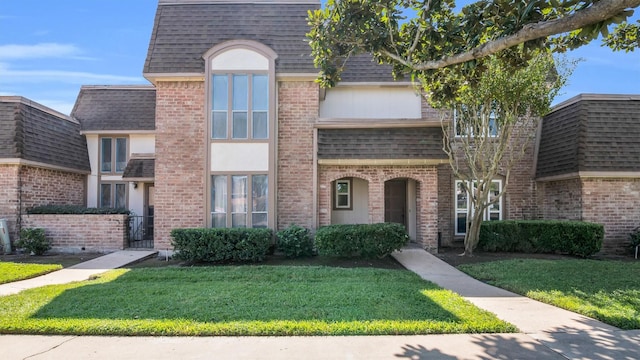 2814 Cambridge Ln, Missouri City, TX 77459 - view of front facade featuring roof with shingles, a front yard, mansard roof, and brick siding