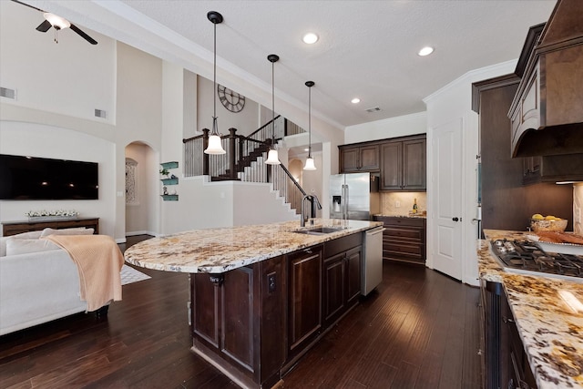 515 Arbor Point Ct, Pinehurst, TX 77362 - kitchen featuring stainless steel appliances, a sink, dark wood-type flooring, dark brown cabinetry, and open floor plan