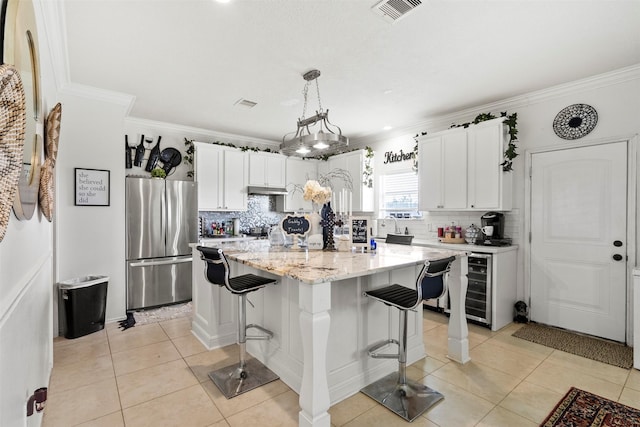 6407 Hillock Ln, Pearland, TX 77584 - kitchen featuring freestanding refrigerator, light tile patterned floors, decorative backsplash, white cabinets, and a center island