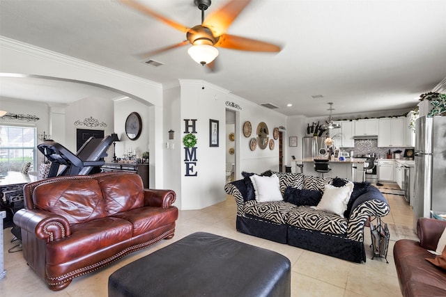6407 Hillock Ln, Pearland, TX 77584 - living room with arched walkways, light tile patterned flooring, a ceiling fan, crown molding, and decorative columns
