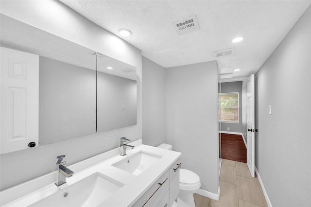 12900 Walden Rd Unit 406D, Montgomery, TX 77356 - bathroom featuring toilet, double vanity, baseboards, and recessed lighting