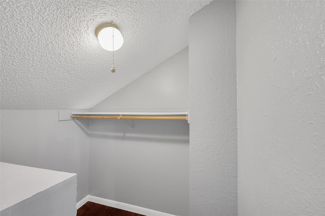 12900 Walden Rd Unit 406D, Montgomery, TX 77356 - walk in closet featuring vaulted ceiling and dark wood-style floors